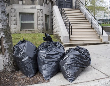Business personnel sorting waste into a commercial skip